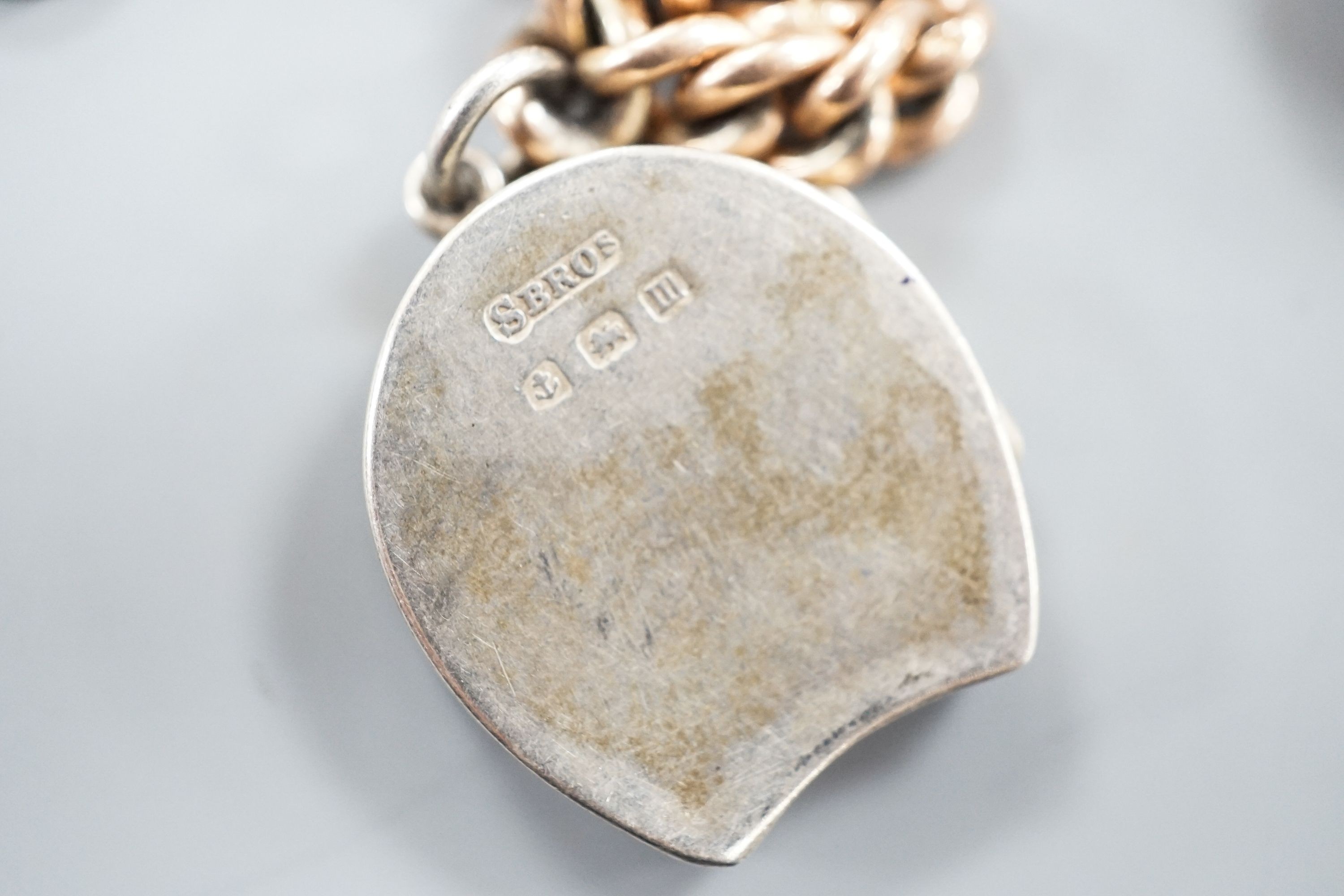 An Edwardian 9ct gold curb link chain, 44cm, hung with a yellow metal locket (gross 36 grams) and a silver locket.